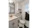 Bathroom features a white toilet, vanity with mirror and black and white tiled floor at 2429 Oak Run Blvd, Kissimmee, FL 34744