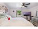 Airy bedroom featuring a ceiling fan, a street view window, and a wall-mounted television at 2429 Oak Run Blvd, Kissimmee, FL 34744