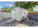 A white storage shed features a ramp for easy access and extra storage, alongside a lounge chair at 2429 Oak Run Blvd, Kissimmee, FL 34744