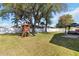 Spacious backyard featuring a playset, mature trees, and a gazebo at 2706 Sebastian Ct, Kissimmee, FL 34743
