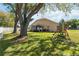 Large grassy backyard featuring mature trees, a gazebo, and a playset at 2706 Sebastian Ct, Kissimmee, FL 34743