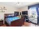 Well-lit bedroom featuring a wood-framed bed, ceiling fan, and a window with curtains at 2706 Sebastian Ct, Kissimmee, FL 34743