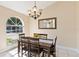 Cozy dining room featuring a chandelier, a wooden table, a decorative mirror, and a large window at 2706 Sebastian Ct, Kissimmee, FL 34743