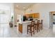 Bright kitchen with tile floors, a breakfast bar, wooden cabinets, and a view of the dining and living areas at 2706 Sebastian Ct, Kissimmee, FL 34743