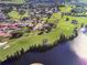 Aerial view of the community, highlighting its proximity to a golf course, lush greenery, and a serene lake at 2809 Wingfoot Ct, Winter Haven, FL 33884