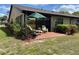 Outdoor patio featuring comfortable seating, a green umbrella, and lush plantings, perfect for relaxation and entertaining at 2809 Wingfoot Ct, Winter Haven, FL 33884