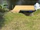 New wooden boat dock on a sunny day with lush green foliage nearby at 3409 Lake Diane Rd, Tavares, FL 32778