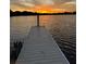 Picturesque dock leading into a tranquil lake with a vibrant sunset and soft light at 3409 Lake Diane Rd, Tavares, FL 32778
