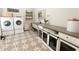 A well-organized laundry room boasts modern machines, stylish flooring, and pet kennels at 3409 Lake Diane Rd, Tavares, FL 32778