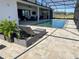 Relaxing poolside with a lounge chair and lush potted plants, screened for comfort and privacy, under a blue sky at 3409 Lake Diane Rd, Tavares, FL 32778
