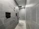 Modern shower with gray tile, dual shower heads, and shampoo niche inserts at 3409 Lake Diane Rd, Tavares, FL 32778