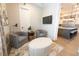 Cozy sitting area with two gray chairs, an ottoman, and a view into the modern kitchen at 3409 Lake Diane Rd, Tavares, FL 32778
