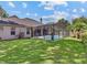 Large backyard with screen-enclosed pool and a view of the rear exterior of the home at 3637 Rothbury Dr, Belle Isle, FL 32812