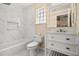 Modern bathroom with white marble walls, a sleek vanity, and a soaking tub at 3637 Rothbury Dr, Belle Isle, FL 32812
