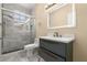 Modern bathroom with marble walk-in shower, blue vanity with plenty of drawer space, and illuminated mirror at 3637 Rothbury Dr, Belle Isle, FL 32812