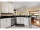 Kitchen featuring stainless steel appliances, black countertops, and a view of the dining area and backyard at 3637 Rothbury Dr, Belle Isle, FL 32812