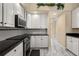 Contemporary kitchen with sleek appliances, white cabinets, and black countertops, blending style and convenience at 3637 Rothbury Dr, Belle Isle, FL 32812