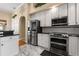 Modern kitchen with stainless steel appliances, white cabinets, and marble floors, offering style and functionality at 3637 Rothbury Dr, Belle Isle, FL 32812