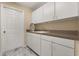 Functional laundry room with ample white cabinetry, sink, and dark countertops at 3637 Rothbury Dr, Belle Isle, FL 32812