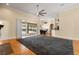 Spacious living room with hardwood floors, a ceiling fan, and sliding doors leading to a screened-in lanai at 3637 Rothbury Dr, Belle Isle, FL 32812