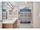 Functional bathroom featuring large vanity, white sink, and shower with decorative curtain at 4561 Yellowgold E Rd # 107, Kissimmee, FL 34746