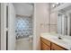 Bright bathroom featuring a wooden vanity with toilet and shower with blue curtain at 4561 Yellowgold E Rd # 107, Kissimmee, FL 34746
