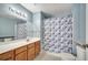 Well-lit bathroom with a large mirror, vanity, and a shower with a floral curtain at 4561 Yellowgold E Rd # 107, Kissimmee, FL 34746