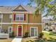 Inviting townhouse with red door, red shutters, sidewalk, and well-maintained landscaping at 4561 Yellowgold E Rd # 107, Kissimmee, FL 34746
