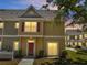 A quaint two-story townhome featuring warm siding, red shutters, and inviting front door at 4561 Yellowgold E Rd # 107, Kissimmee, FL 34746
