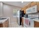 Functional kitchen with white appliances, classic cabinets, and bright natural light at 4561 Yellowgold E Rd # 107, Kissimmee, FL 34746