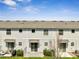 Backyard of a townhome with a patio, green grass and manicured landscaping at 4672 Tribute Trl, Kissimmee, FL 34746
