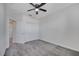 This bedroom features a ceiling fan, gray carpet, white walls, and a closet with bi-fold doors at 4672 Tribute Trl, Kissimmee, FL 34746