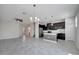 Bright and modern living area leading to the kitchen with black cabinetry and a center island at 4672 Tribute Trl, Kissimmee, FL 34746