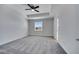 The main bedroom features a tray ceiling, fan, window, and gray carpeting at 4672 Tribute Trl, Kissimmee, FL 34746