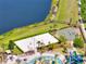 Aerial view of community park featuring a volleyball court, basketball court, splash pad, and lounge chairs at 4672 Tribute Trl, Kissimmee, FL 34746