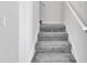 Carpeted staircase with white banister and walls leading to the upper level of the home at 4672 Tribute Trl, Kissimmee, FL 34746