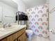 Bathroom featuring a charming rainbow shower curtain and coordinated storage at 4858 S Semoran Blvd # 2108, Orlando, FL 32822