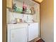 Functional laundry area with washer, dryer, and shelving for storage at 4858 S Semoran Blvd # 2108, Orlando, FL 32822