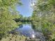 Scenic view of a tranquil pond surrounded by lush trees and clear blue skies, perfect for nature lovers at 4858 S Semoran Blvd # 2108, Orlando, FL 32822