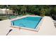 Community pool with lounge chairs and ample deck space, perfect for enjoying sunny days and relaxation at 4858 S Semoran Blvd # 2108, Orlando, FL 32822