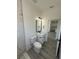 Modern bathroom features sleek vanity, black hardware, wood-look flooring, and tiled walk-in shower at 4863 Sw 159Th Ln Rd, Ocala, FL 34473