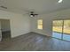 Large bedroom with wood-look flooring, ceiling fan, window and sliding glass door at 4863 Sw 159Th Ln Rd, Ocala, FL 34473