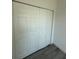 Bedroom closet features bi-fold doors and gray wood look flooring at 4863 Sw 159Th Ln Rd, Ocala, FL 34473