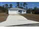 Charming single-story home featuring a blue exterior, white accents, a gray roof, and a concrete driveway at 4863 Sw 159Th Ln Rd, Ocala, FL 34473
