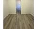 Hallway leading to bathroom featuring wood-look flooring and white trim at 4863 Sw 159Th Ln Rd, Ocala, FL 34473