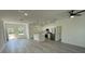 Open-concept living and kitchen area with modern fixtures, stainless steel appliances, and sleek gray flooring at 4863 Sw 159Th Ln Rd, Ocala, FL 34473