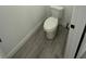 Close-up of toilet in bathroom featuring wood-look floors and neutral color scheme at 4863 Sw 159Th Ln Rd, Ocala, FL 34473