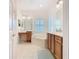 Bright bathroom with tile flooring, a garden tub, and wooden vanity at 501 Heartwell Dr, Poinciana, FL 34759