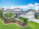 Beautiful one-story home with a well-manicured lawn, mature trees, and a two-car garage at 501 Heartwell Dr, Poinciana, FL 34759