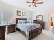 Main bedroom featuring a wood-framed bed, carpet flooring, and an ensuite bathroom at 501 Heartwell Dr, Poinciana, FL 34759